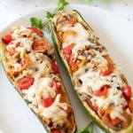 sausage and mushroom zucchini boats on white plate