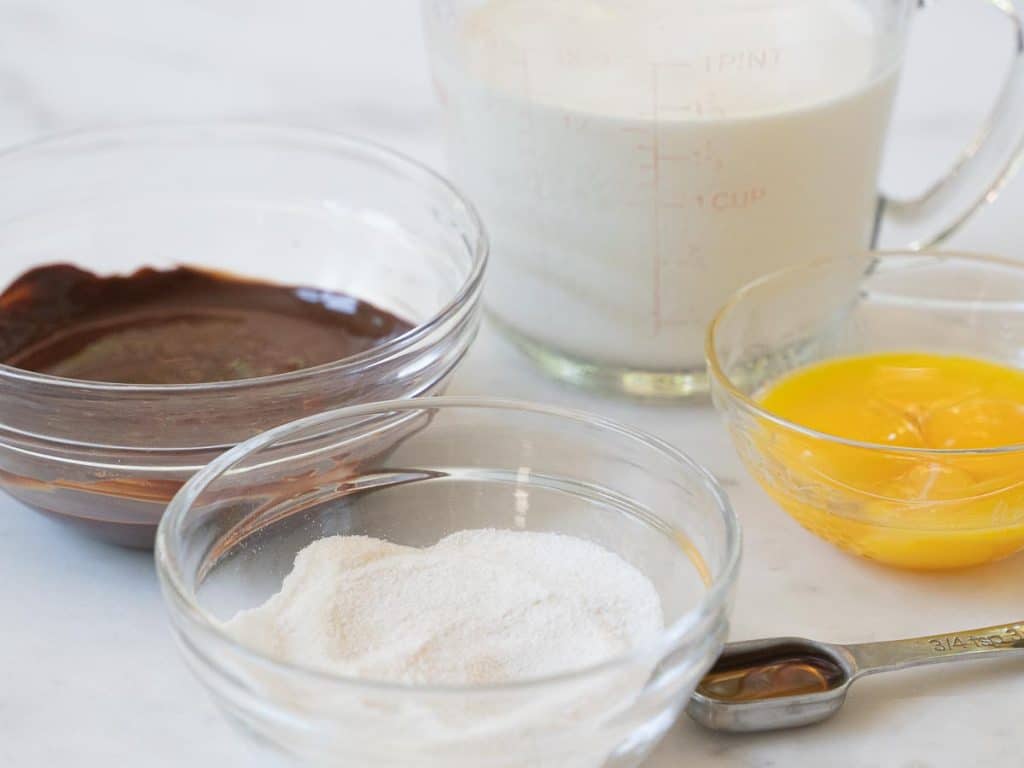 melted chocolate, sugar substitute, half and half and egg yolk in glass dishes