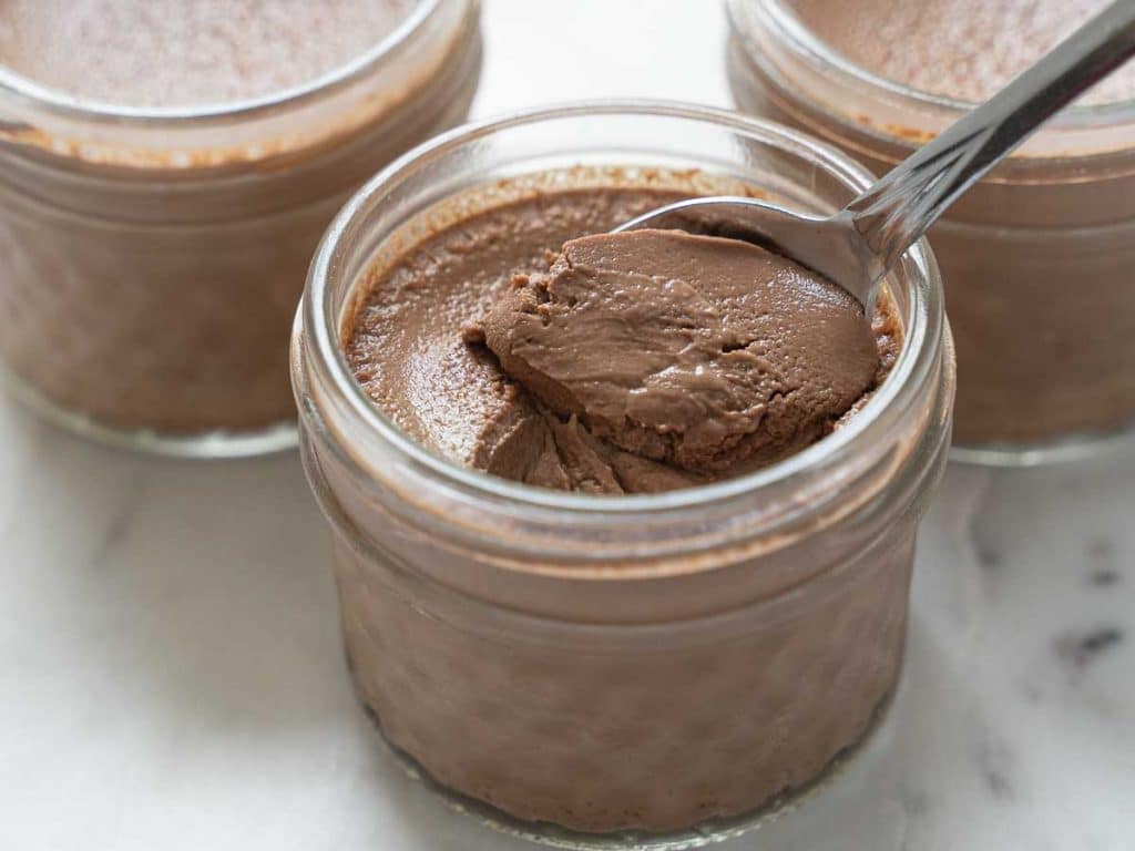 spoonful of chocolate custard in the mini glass mason jars