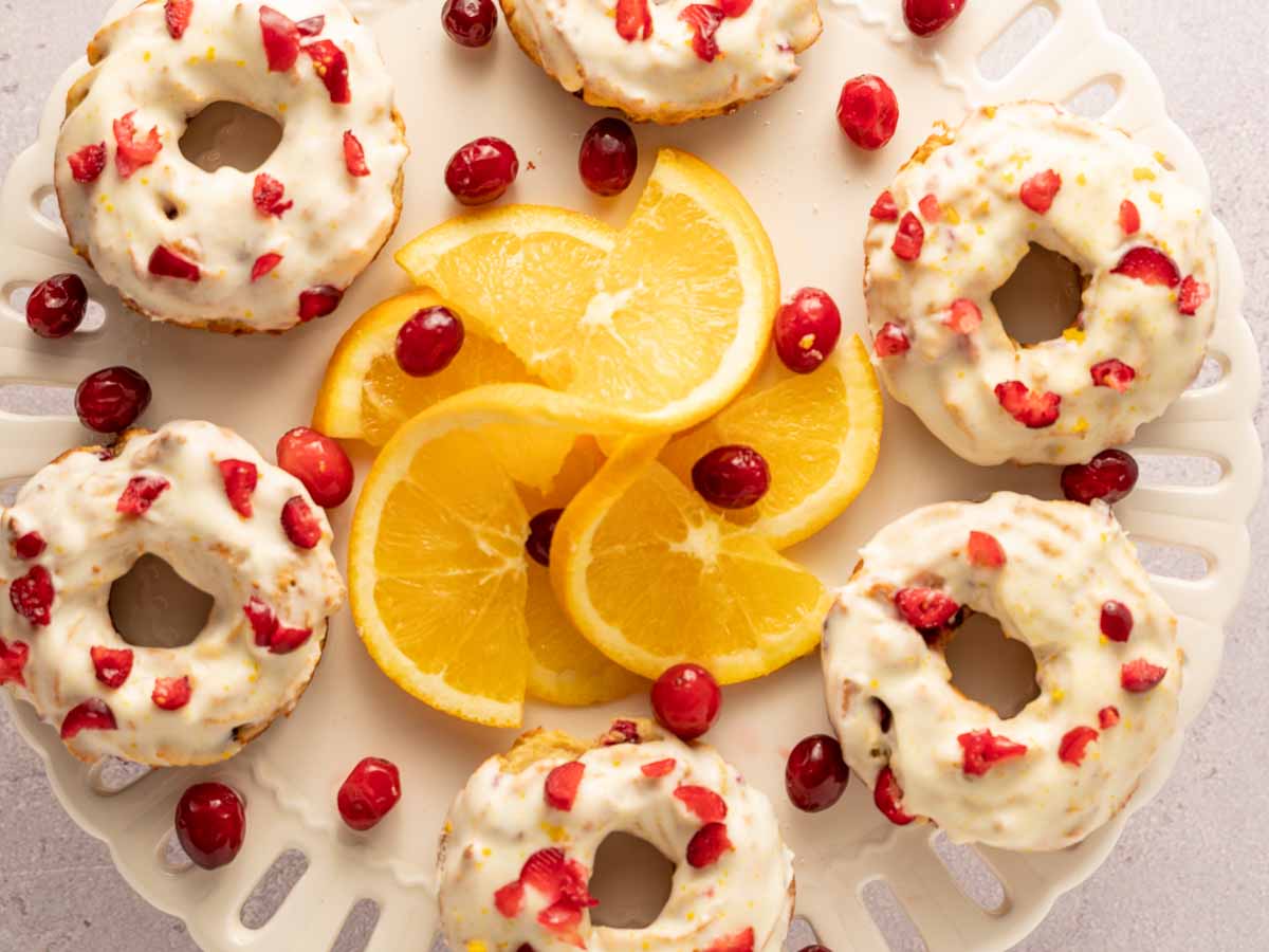 keto cranberry donuts with orange slice on white platter
