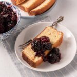 blackberry compote and poundcake on white plate