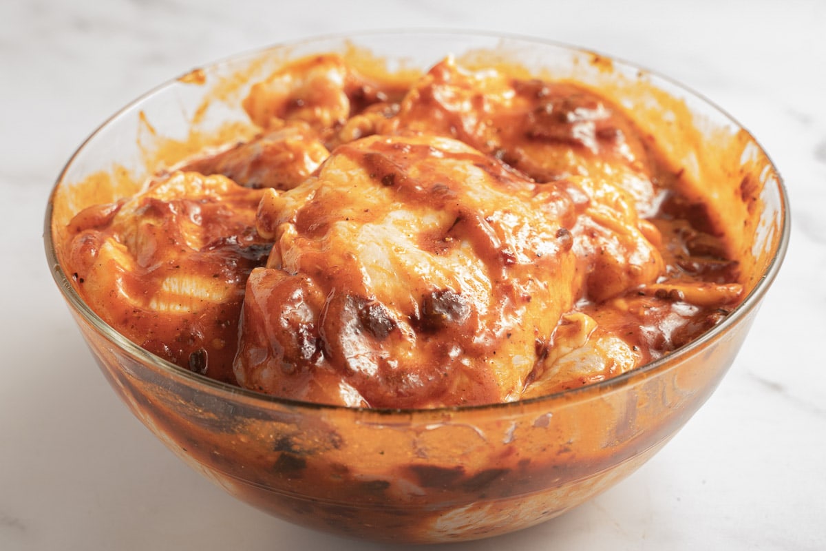 marinated chicken thighs in glass bowl