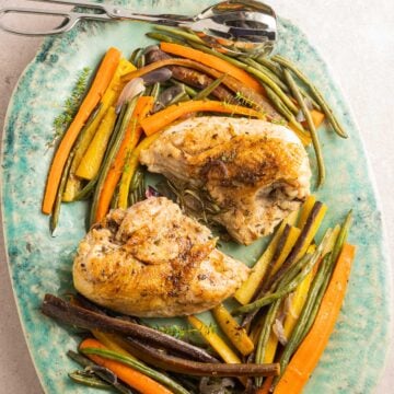 baked chicken, vegetables on green platter.