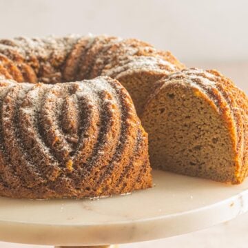 keto pumpkin cake with slice on cake stand.
