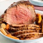 Air Fryer Roast Beef with carrots on white platter.
