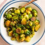 brussel sprouts in white bowl with spoon.