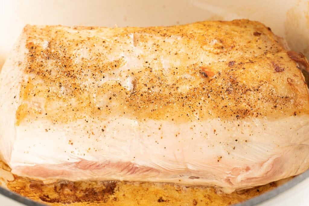 Browned pork roast in dutch oven.