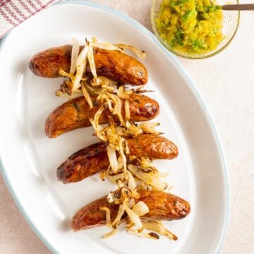 chicken sausage with onions on platter and mustard relish.