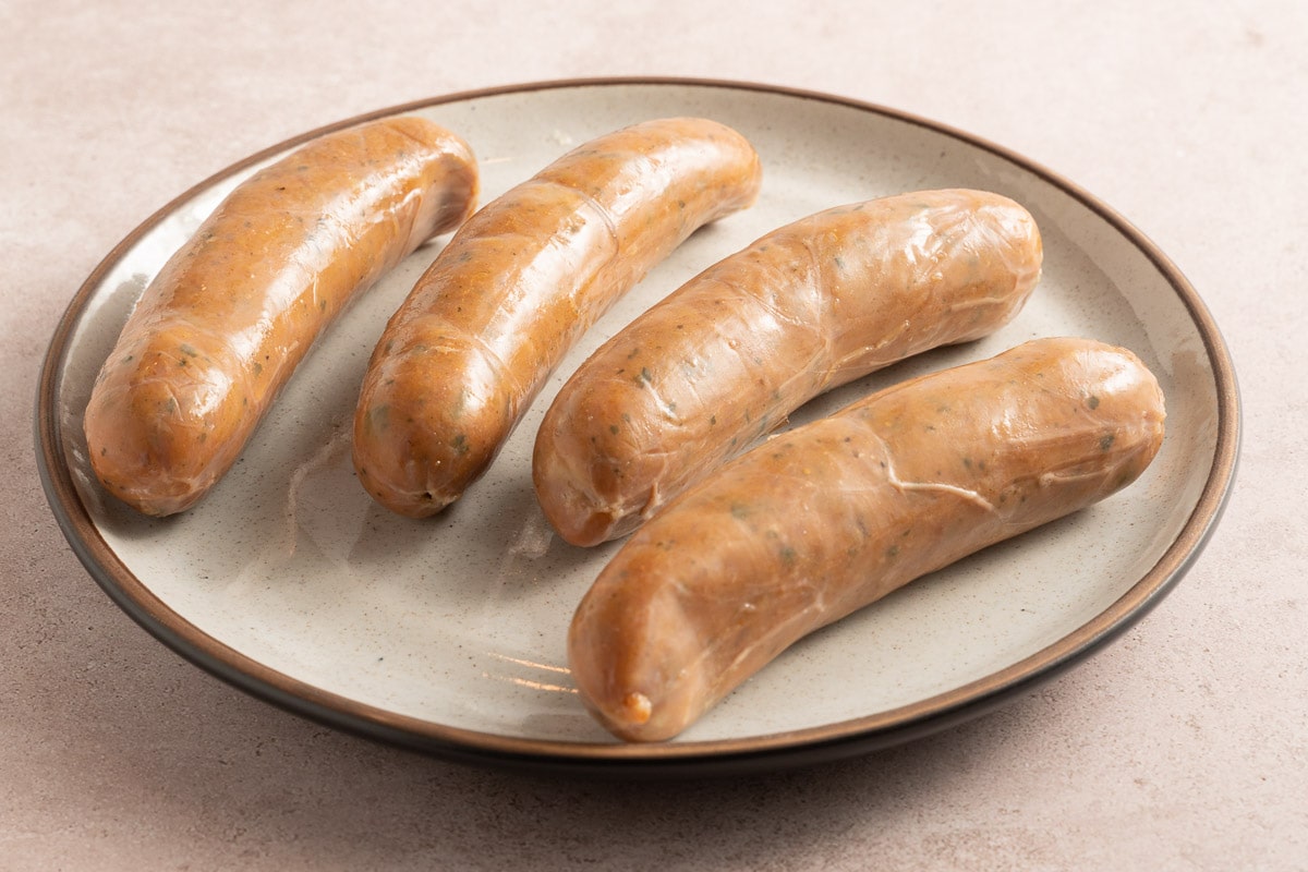 uncooked chicken sausages on plate.