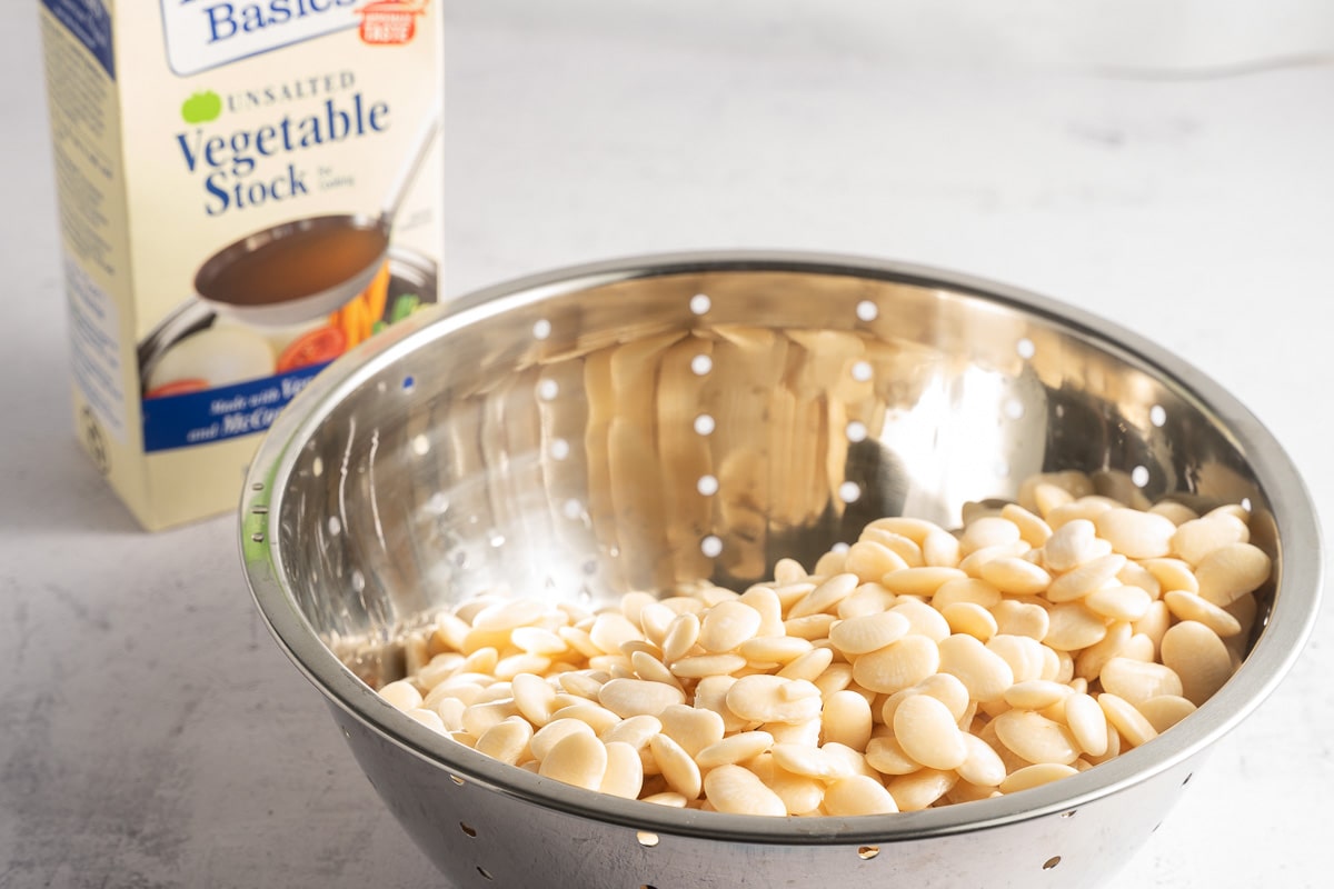 lima beans in colander, vegetable stock.