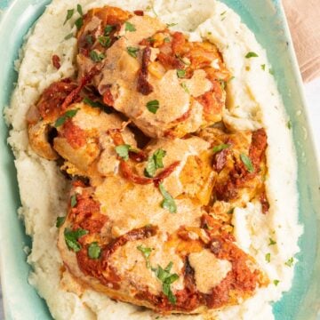chicken paprika and mashed cauliflower on green platter.