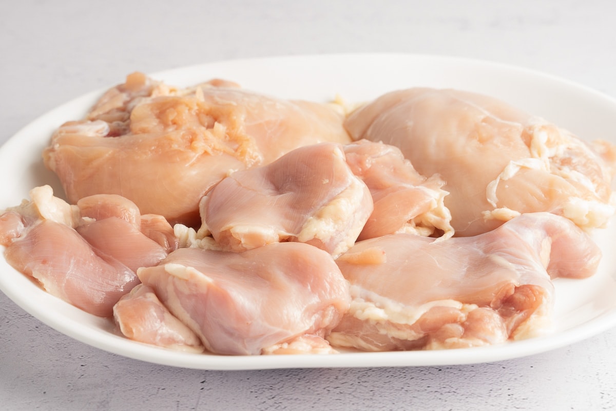 raw chicken thighs and breasts on plate.