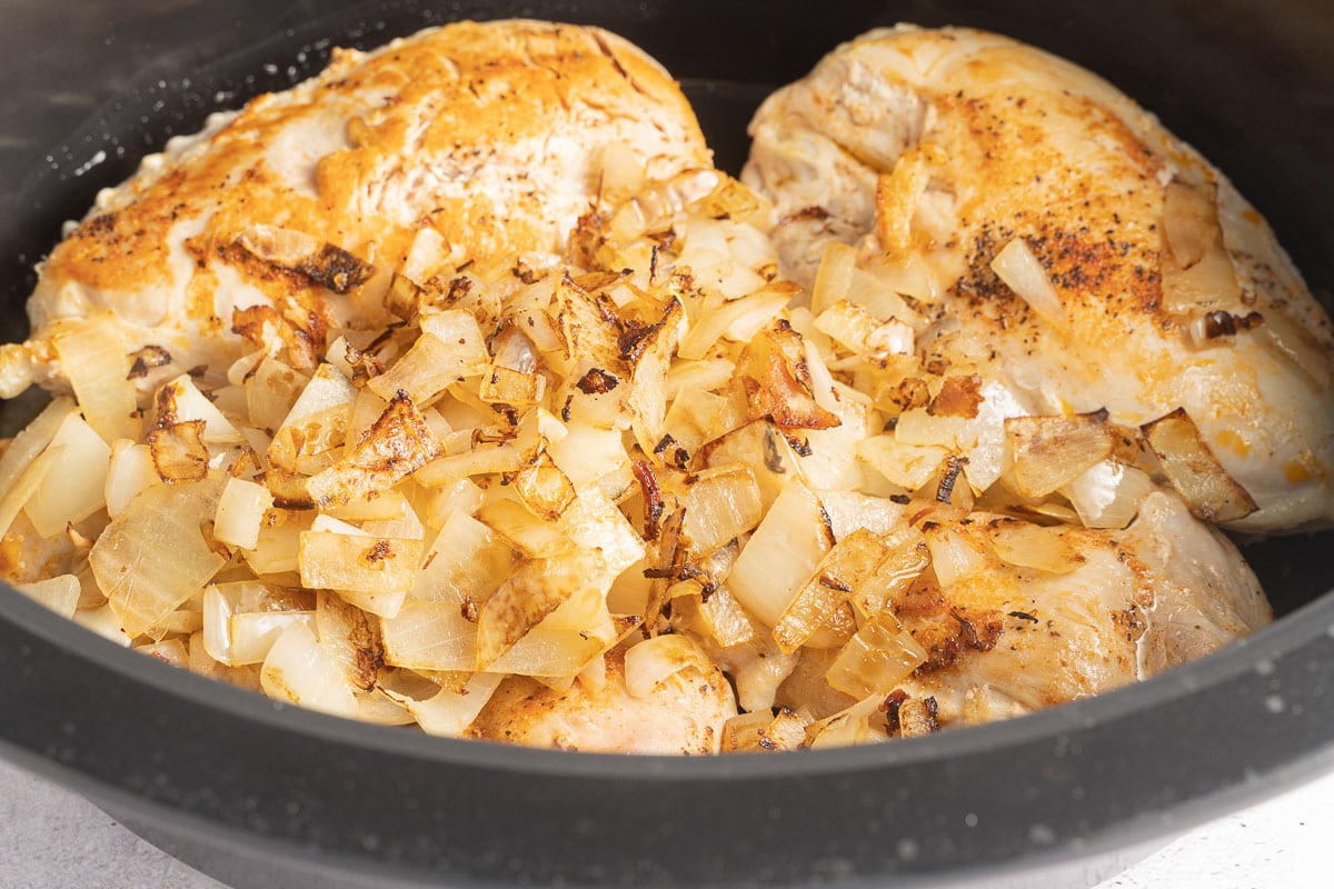 browned onions and chicken in slow cooker.