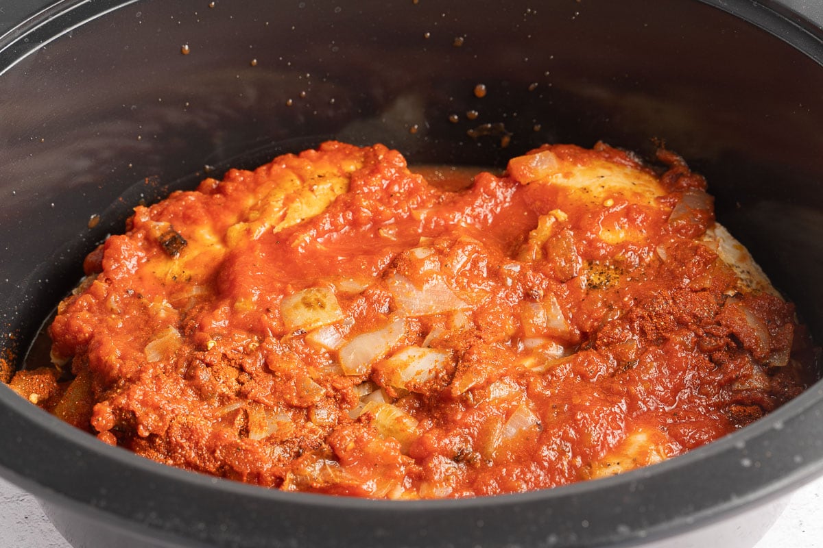 chicken, crushed tomatoes, onions in slow cooker.