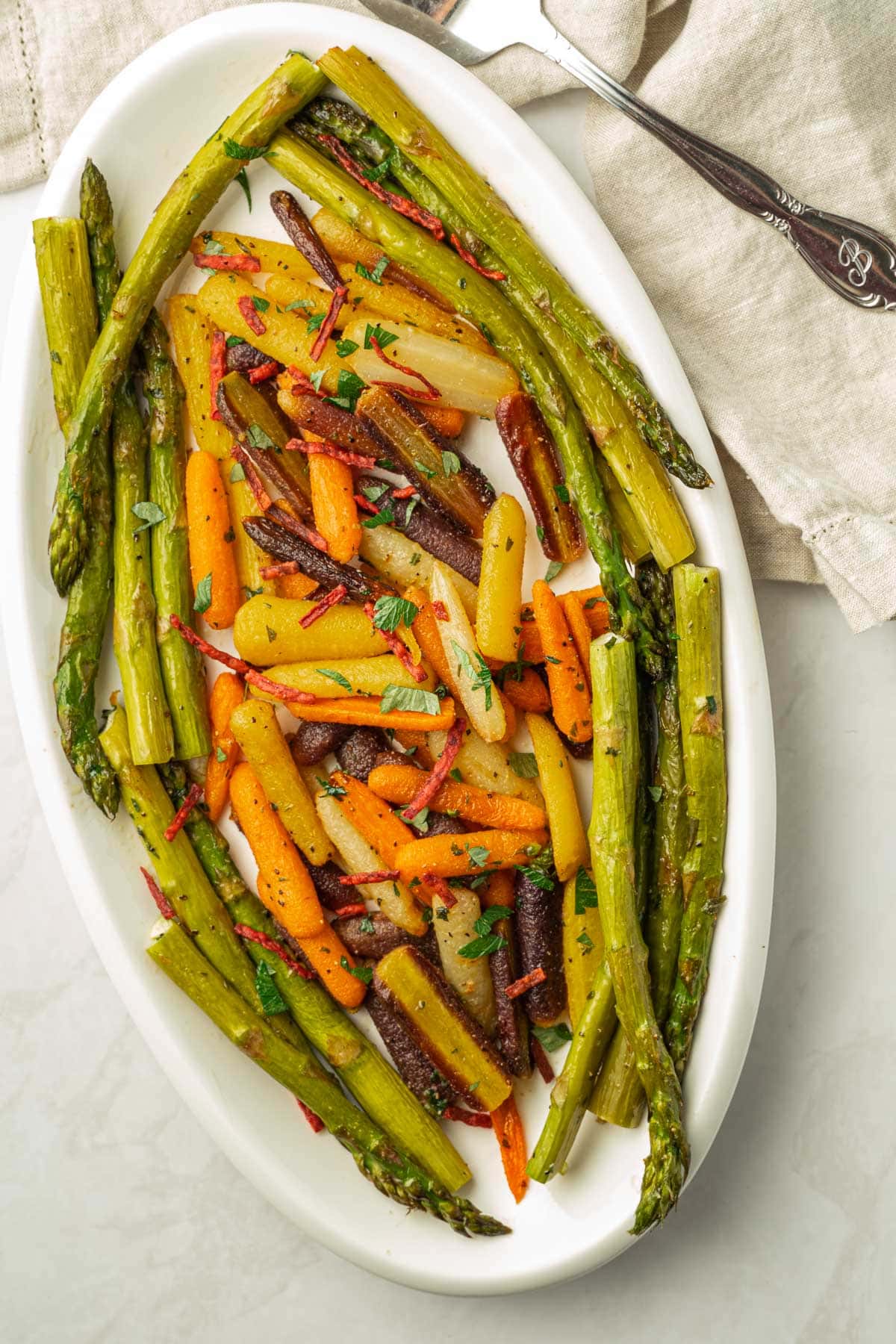 asparagus and carrots on white platter.
