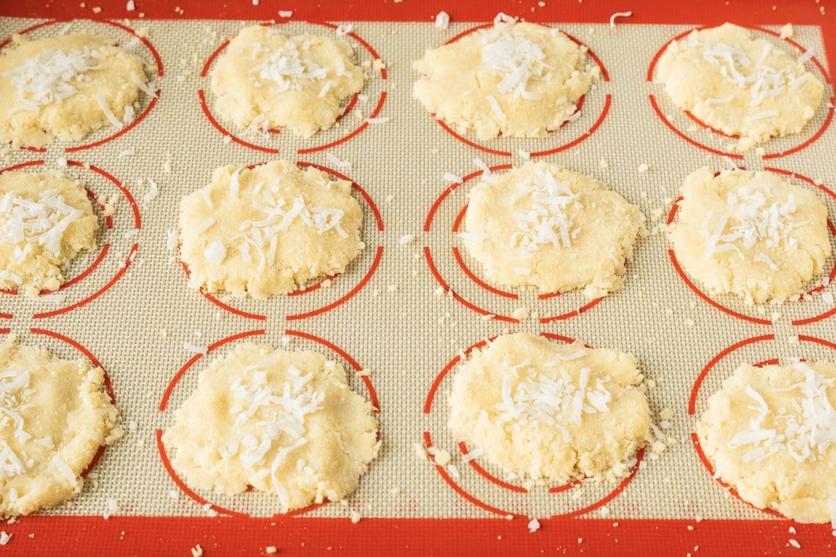 unbaked coconut cookies on pan silicone sheet.