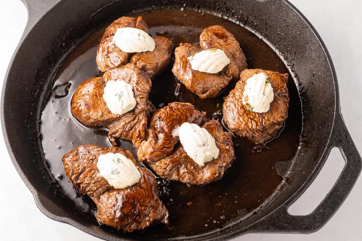 filet medallions with butter in skillet.
