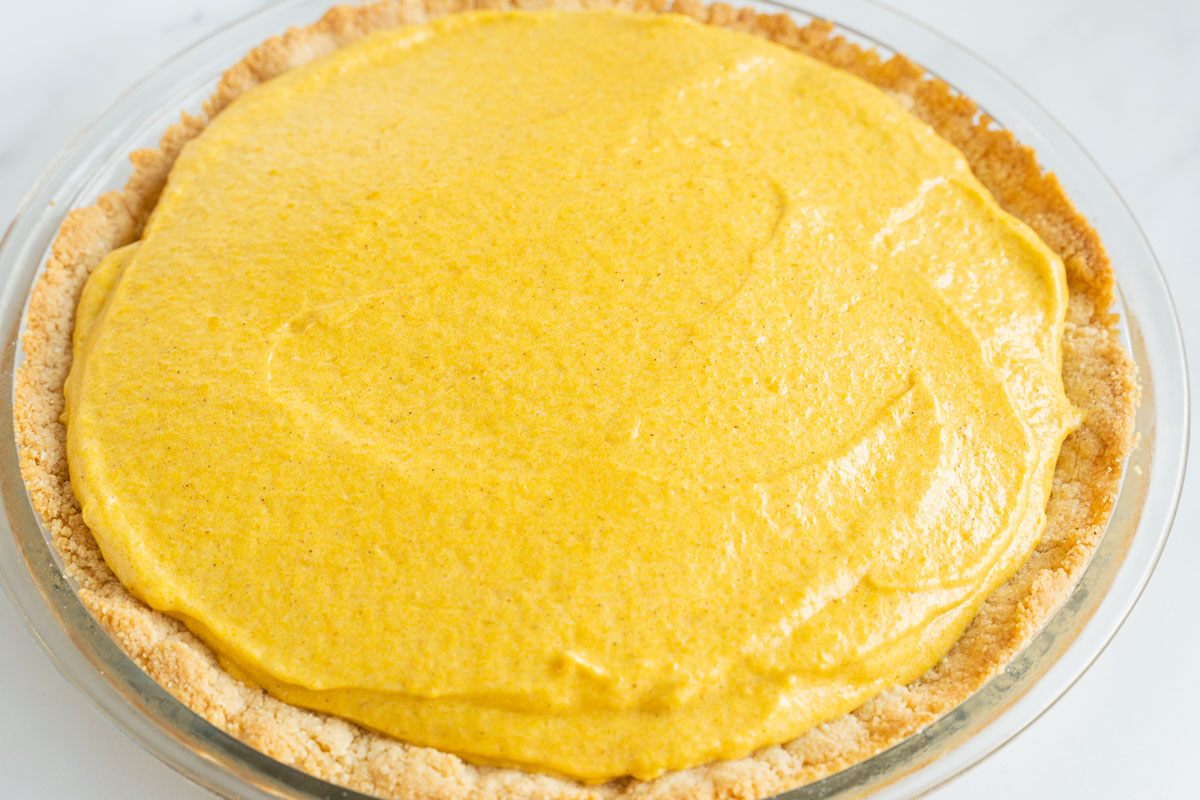 Keto pumpkin chiffon pie in glass plate.
