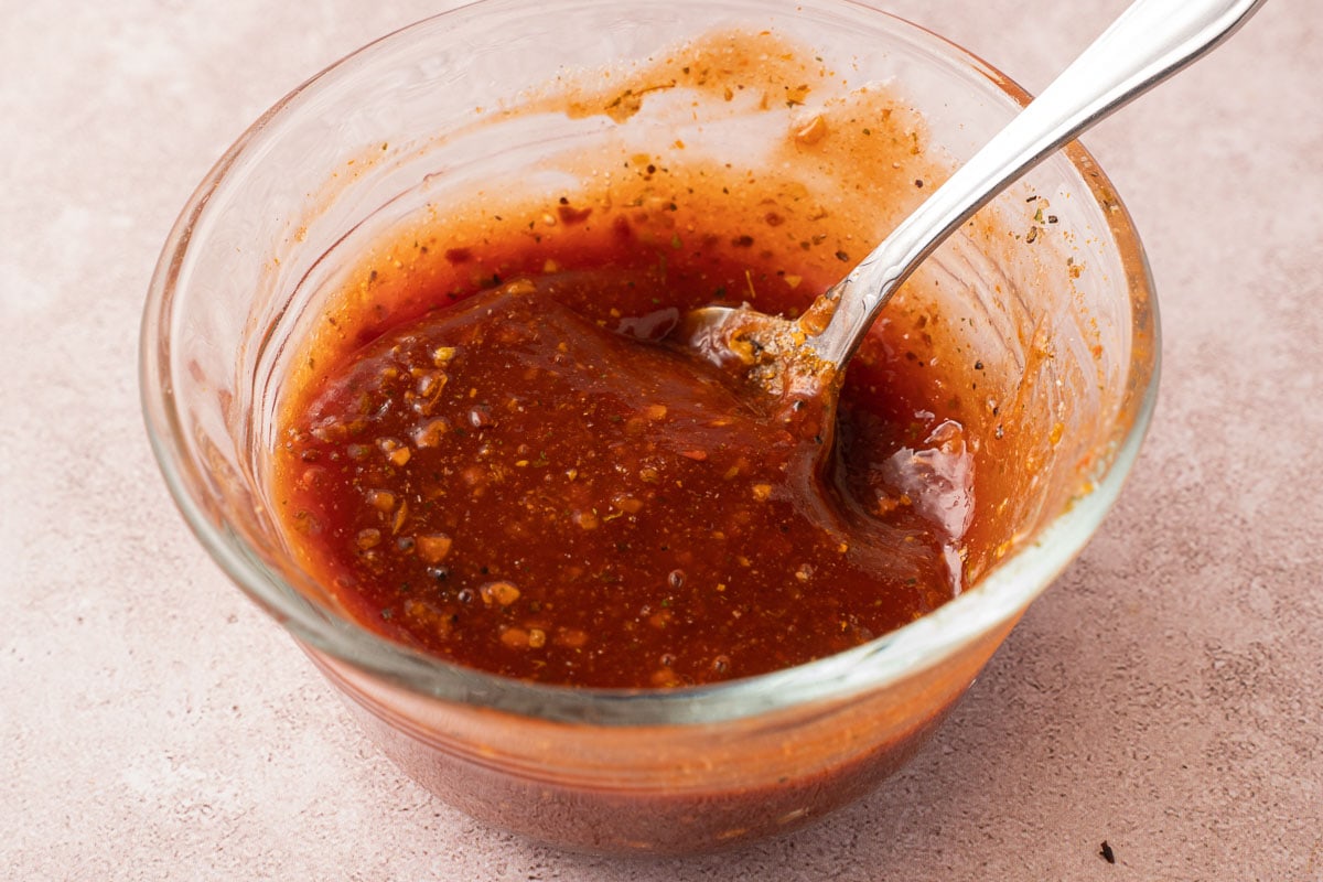 Ketchup, spices, brown sugar in small glass bowl.