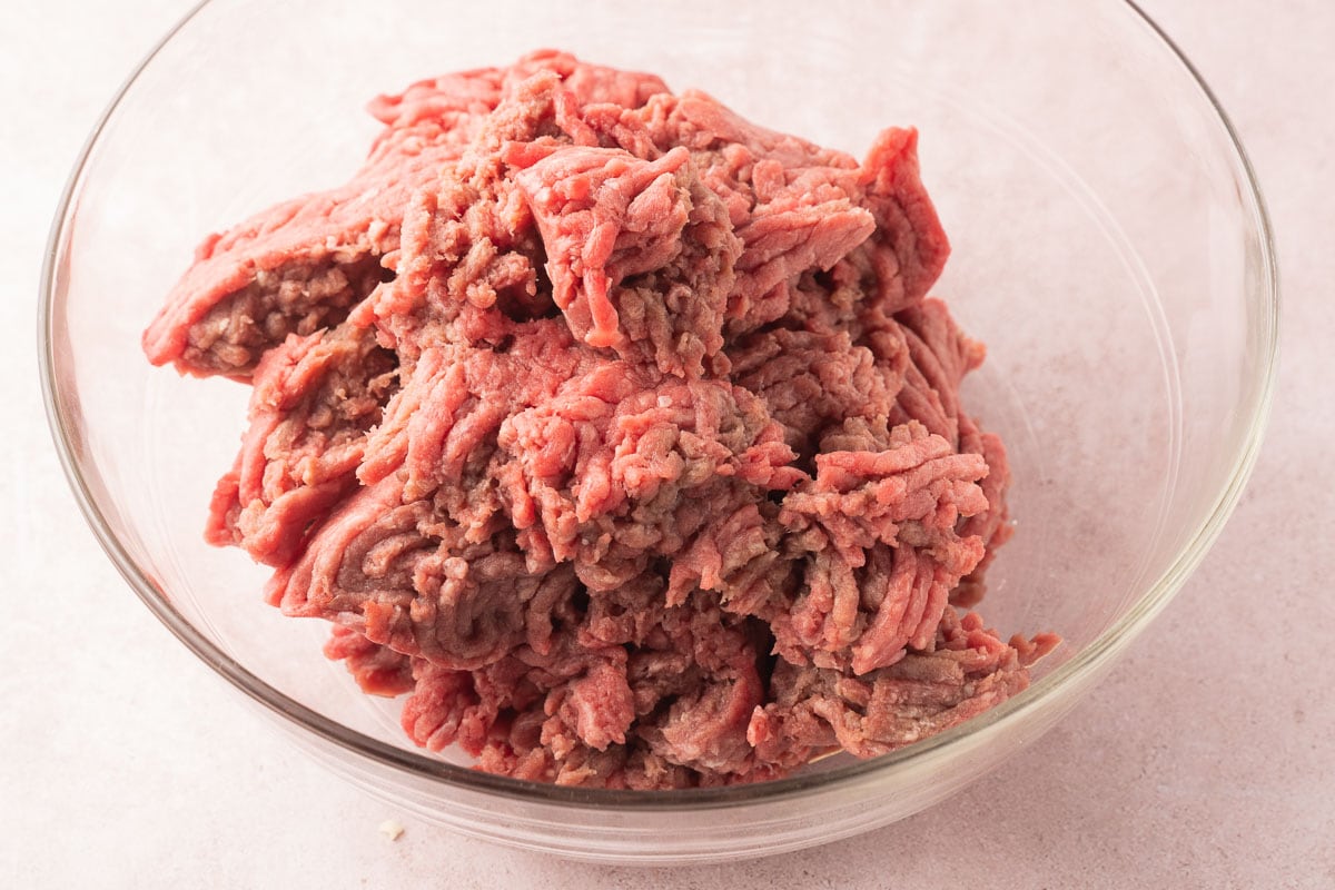 Ground beef in glass bowl.