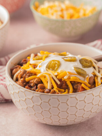 Dutch oven chili, shredded cheese in bowls.