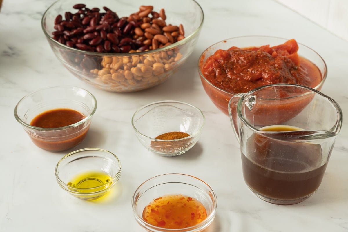 beans, crushed tomatoes, chili seasonings, chili sauce, chipotle sauce in glass bowls, beef broth.