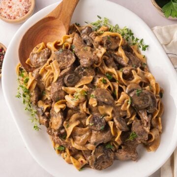 Beef Stroganoff on plate with wooden spoon.