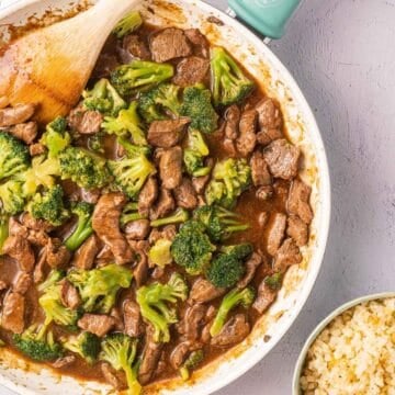 Teriyaki beef and broccoli in skillet and rice in bowl.