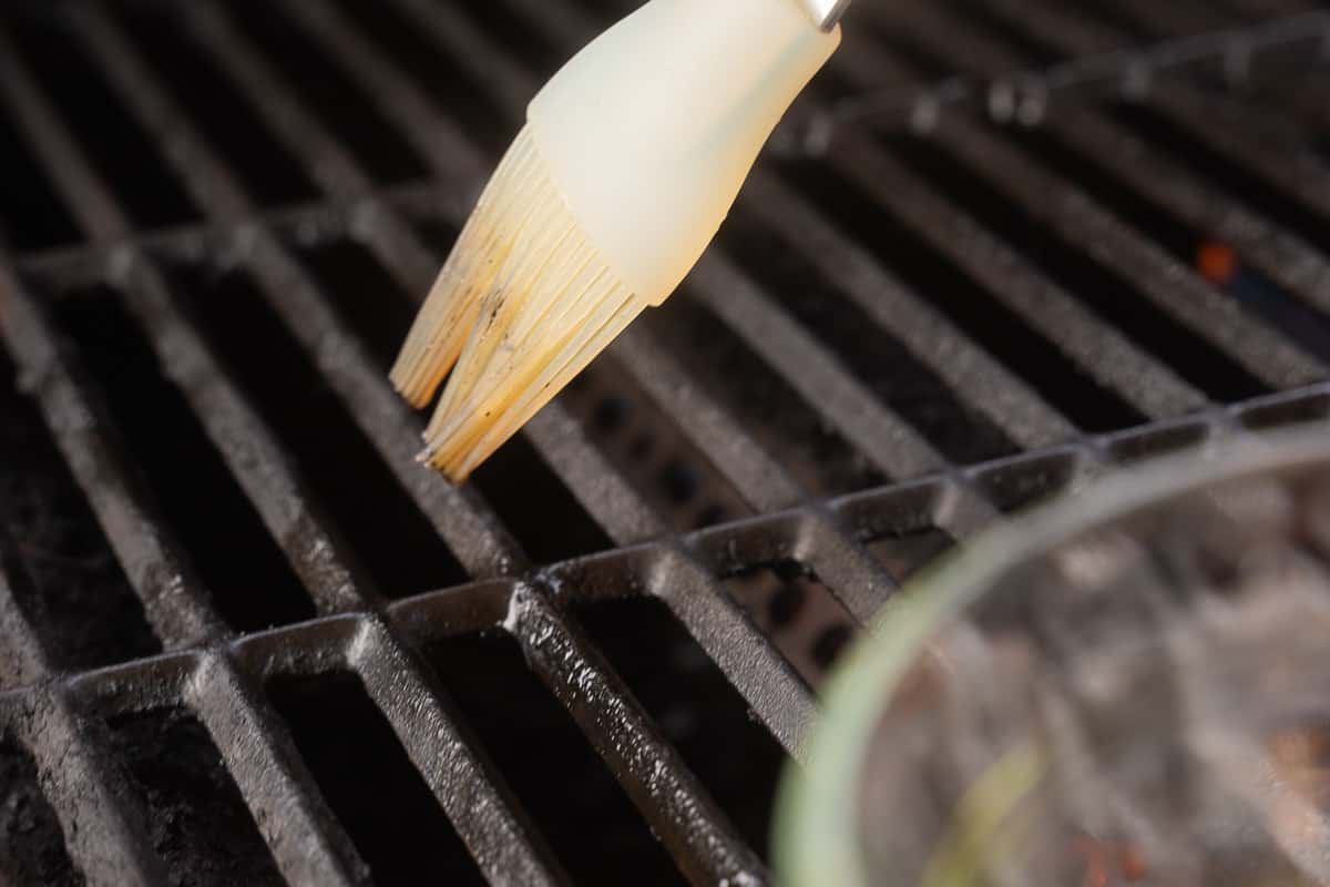 Brushing oil on grill grates.