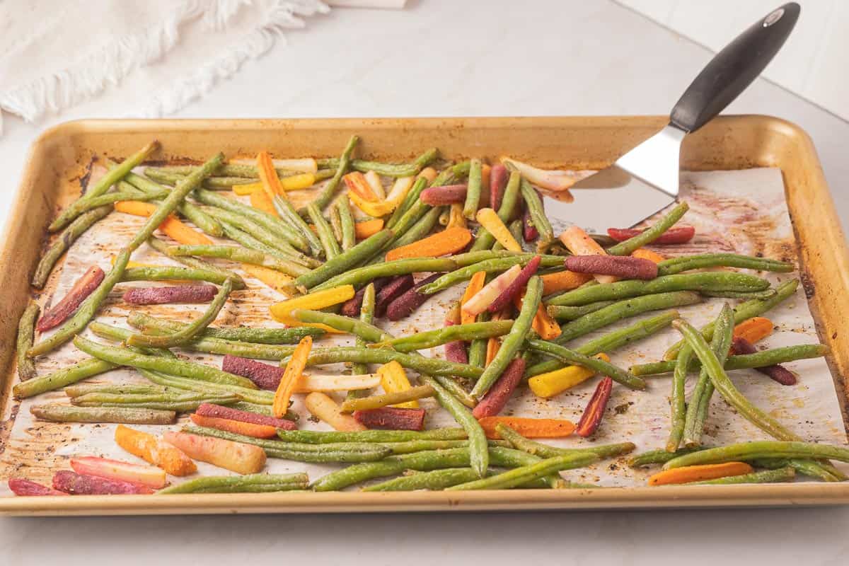 Roasted frozen green beans and carrots on sheet pan.