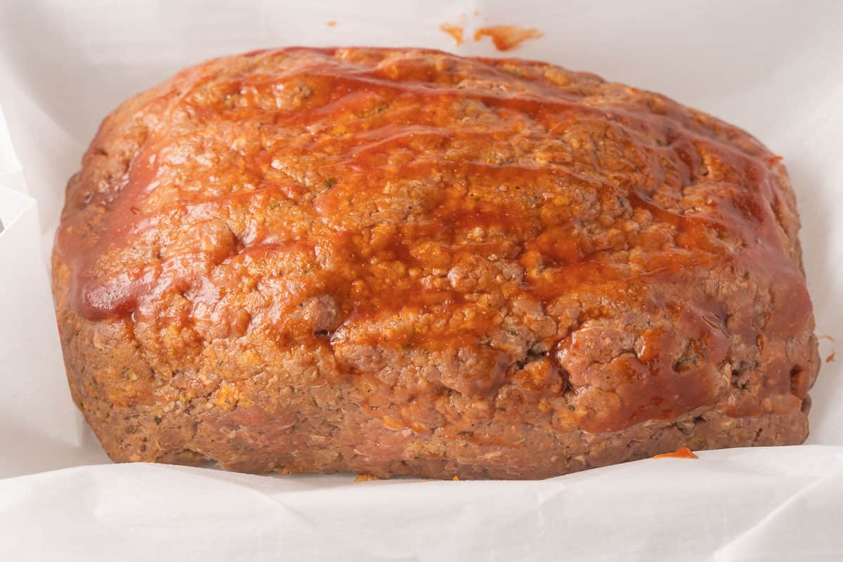 Raw Meatloaf in casserole dish with parchment.