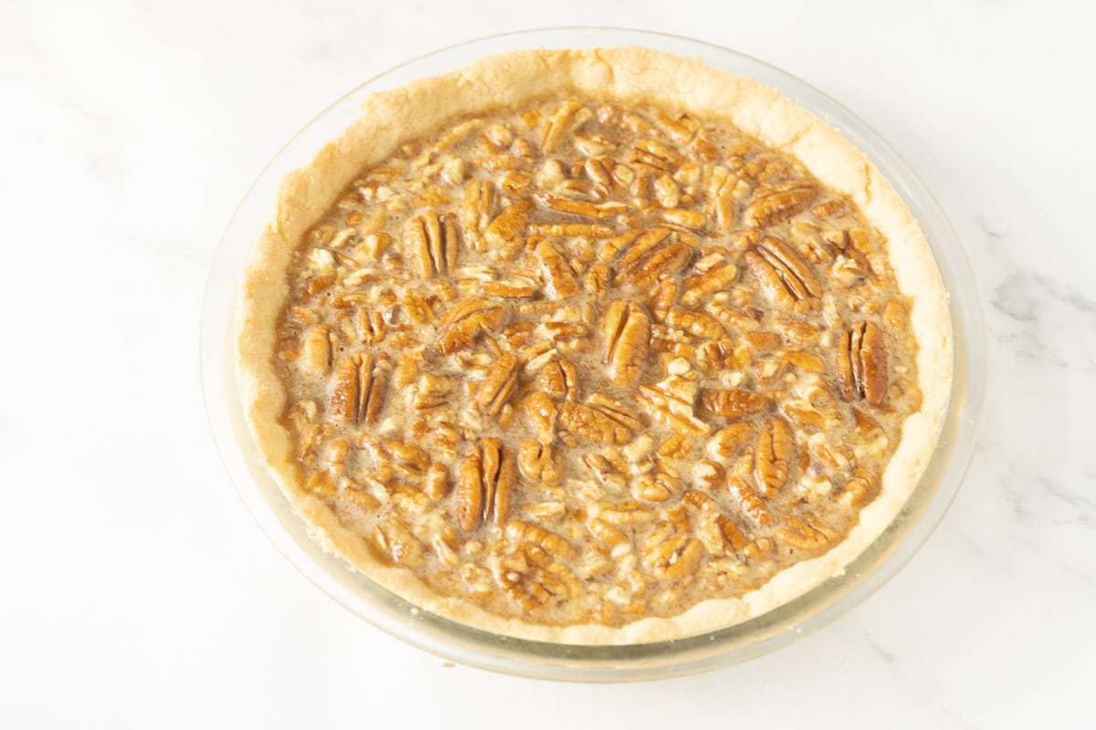 Uncooked pecan pie in pie plate.