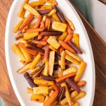 Honey roasted carrots and parsnips on white platter.
