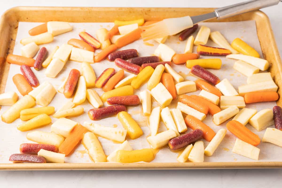 Honey glazed carrots and parsnips on baking tray.