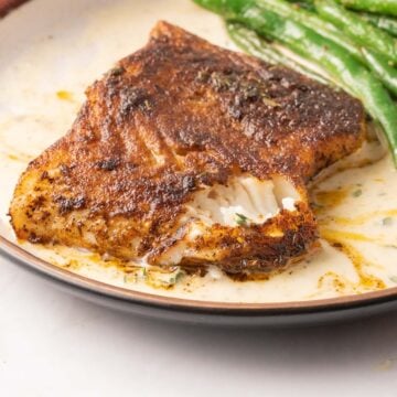 Blackened Chilean Sea Bass on plate with green beans.