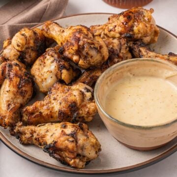 Grilled lemon pepper wings on plate with lemon aioli