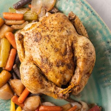 Dutch oven roast chicken and vegetables on platter.