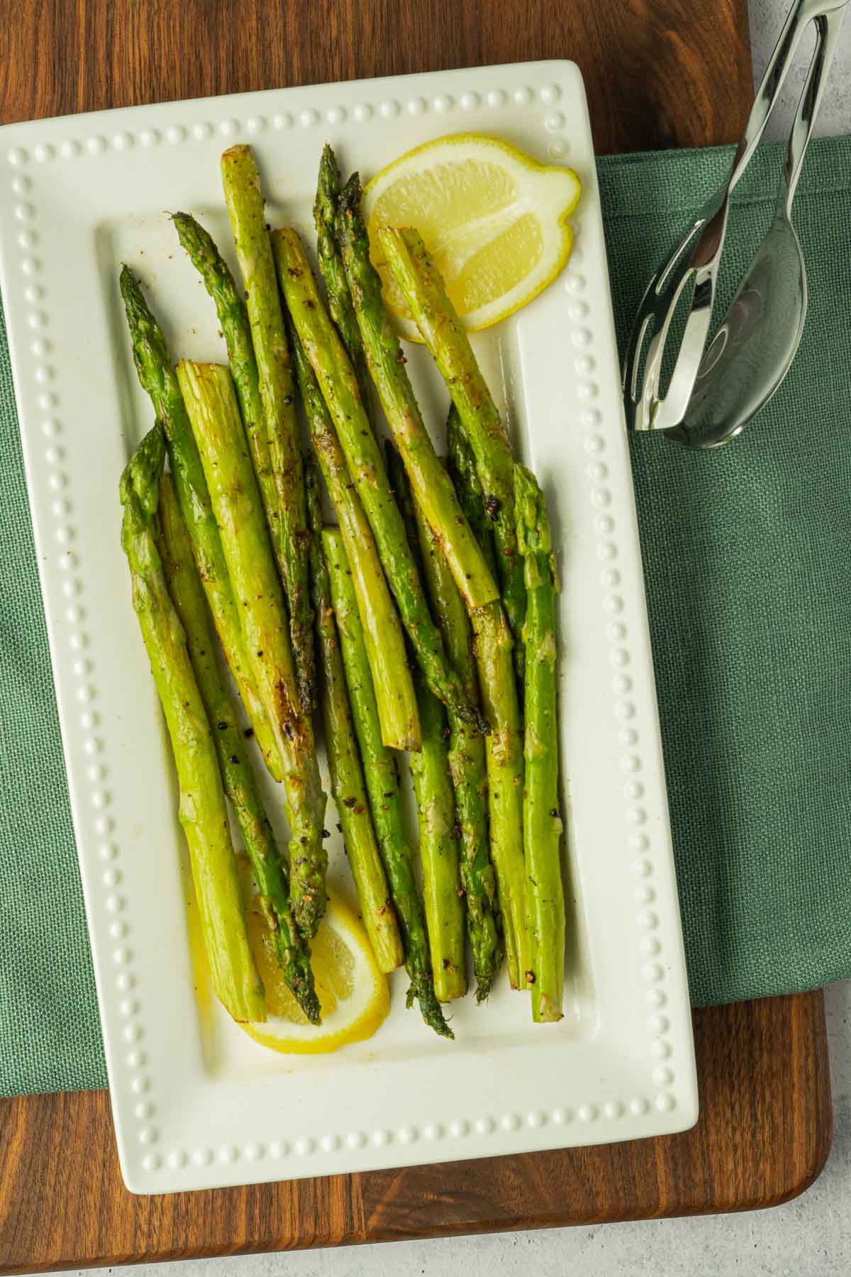 Sautéed Asparagus and lemon on white plate.