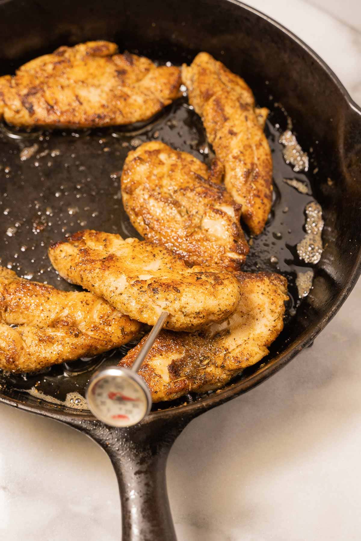 Blackened chicken tenders in skillet.