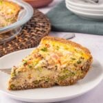 Asparagus and Ham Quiche on white plate with fork.