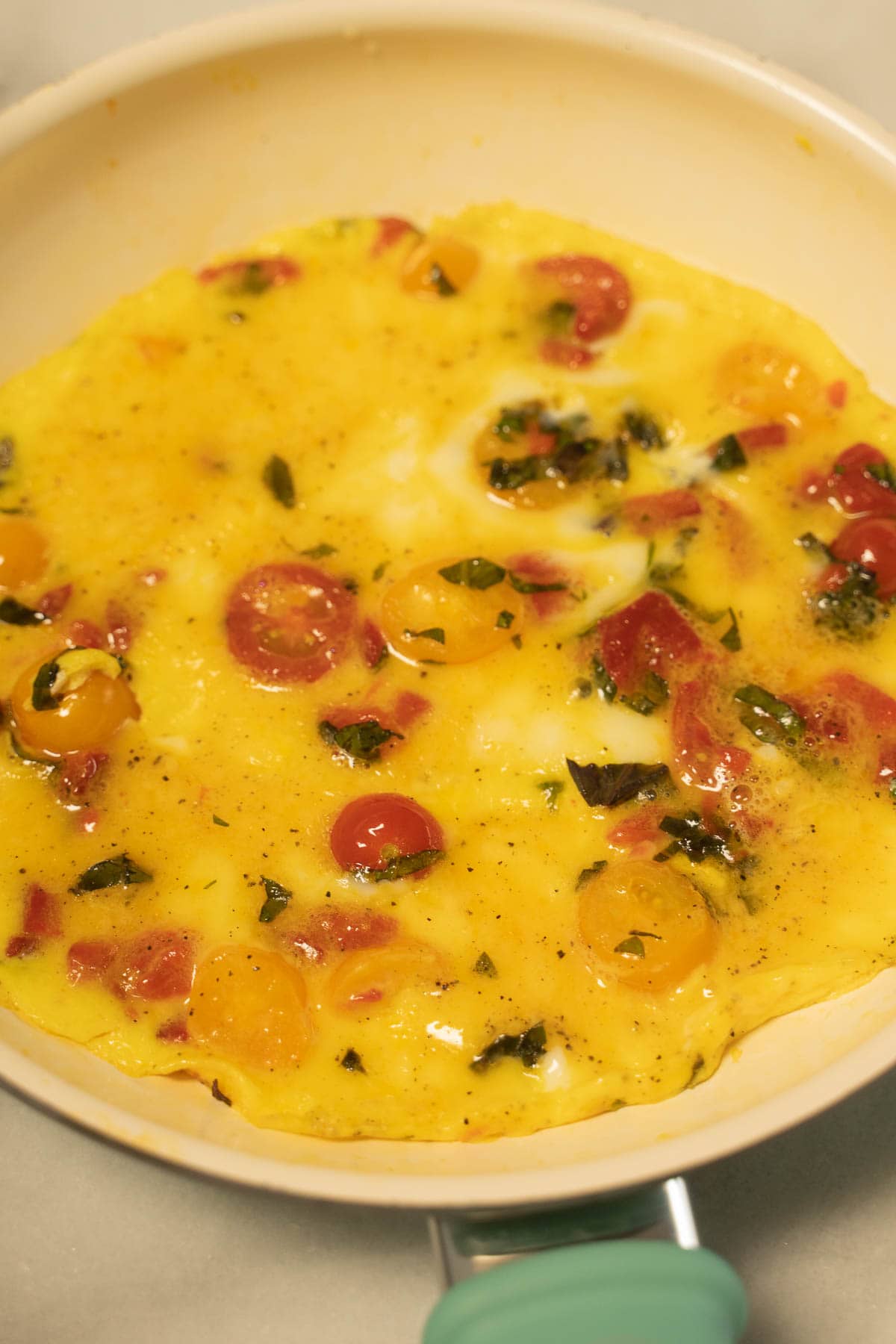 Cooking eggs with tomato and basil.