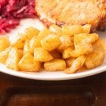 Air Fryer Apples, pork chop and red cabbage on white plate.
