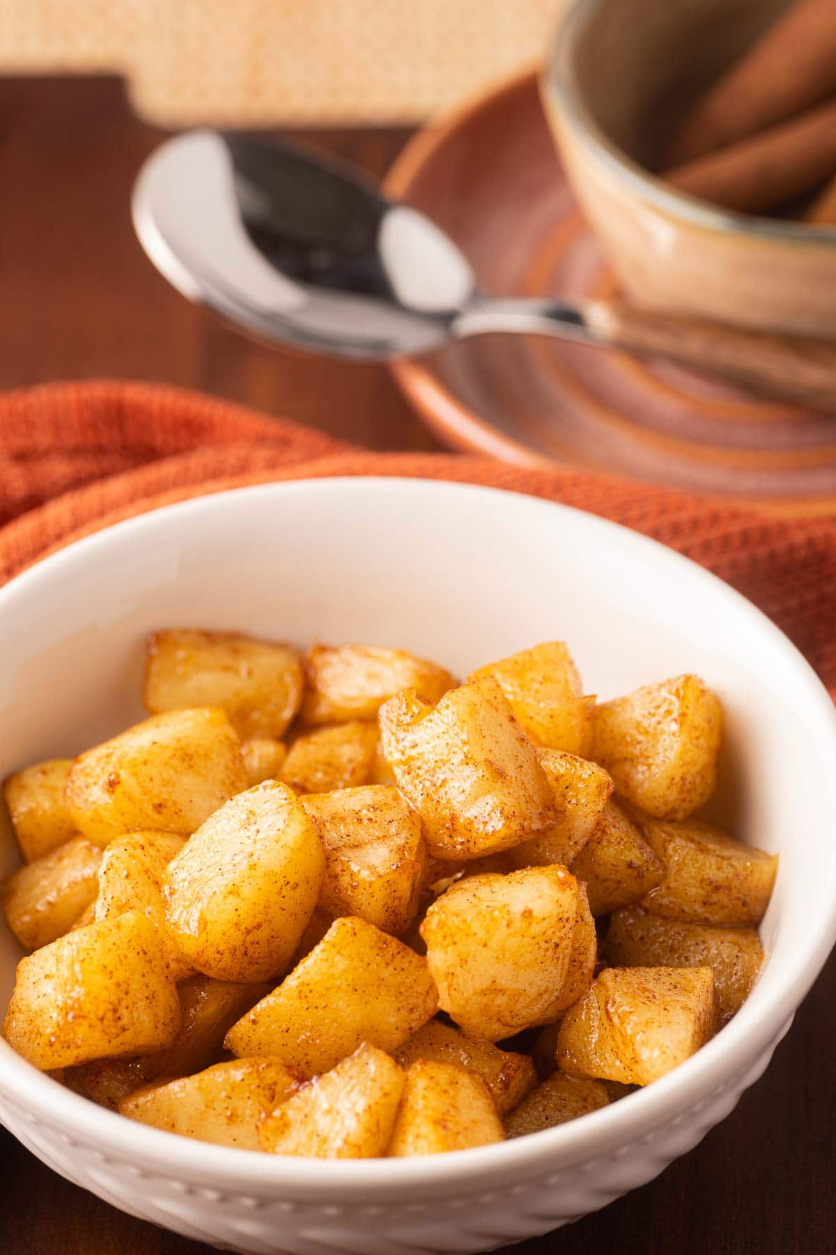 Air Fryer Apples and cinnamon sticks in bowls.
