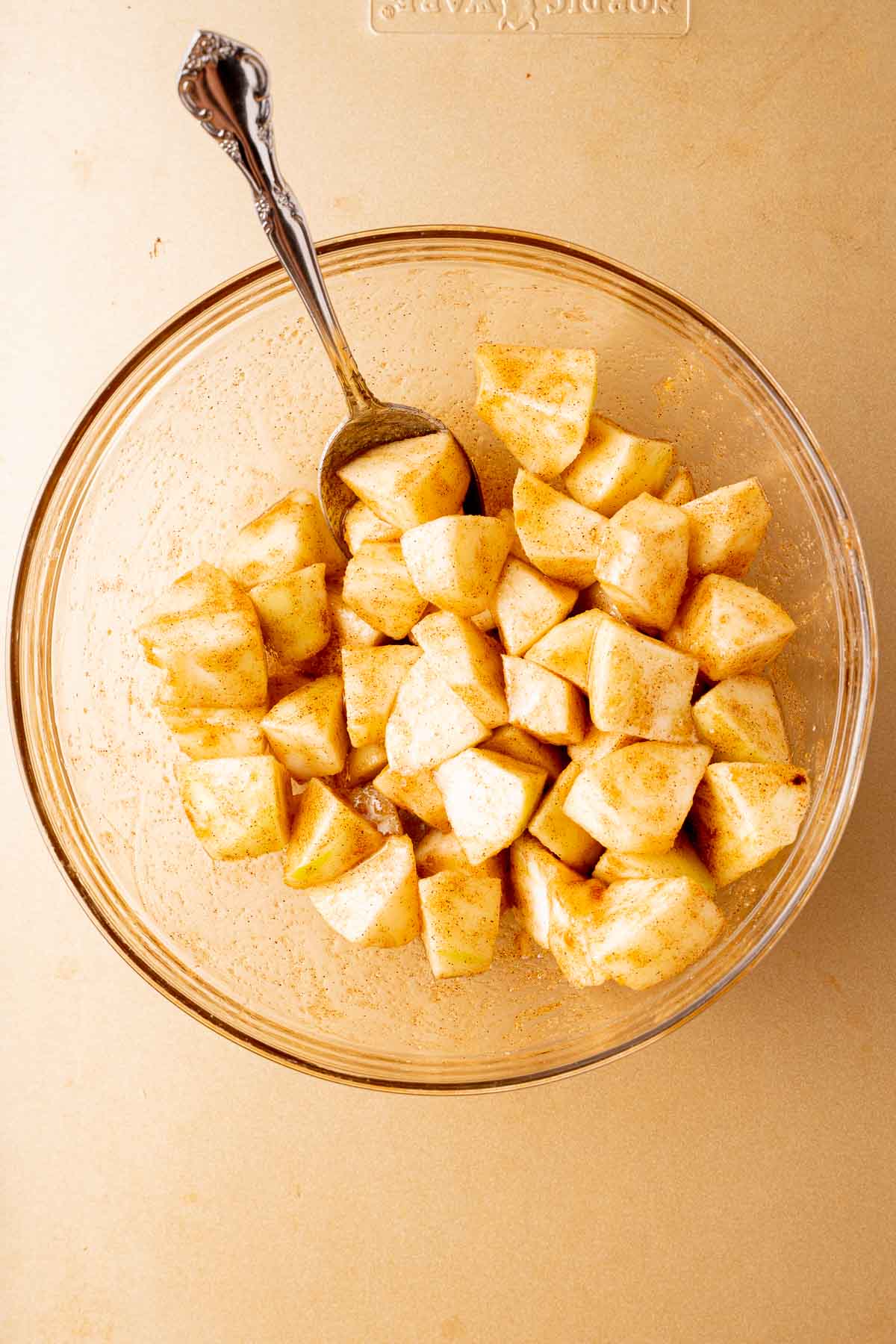 Chopped spiced apples in glass bowl.