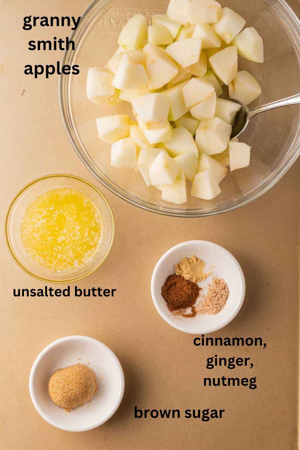 Chopped apples in bowl, melted butter, spices, brown sugar.