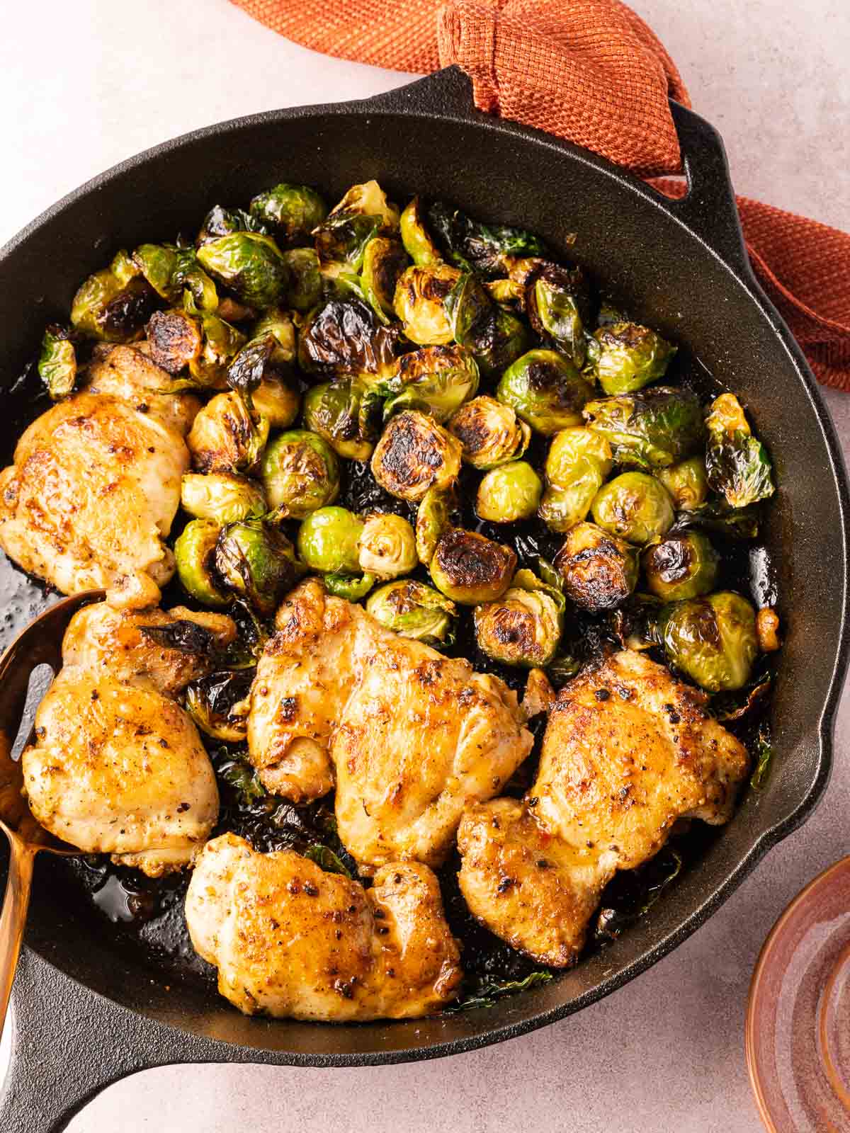 Hot honey chicken and brussels sprouts in cast iron skillet.