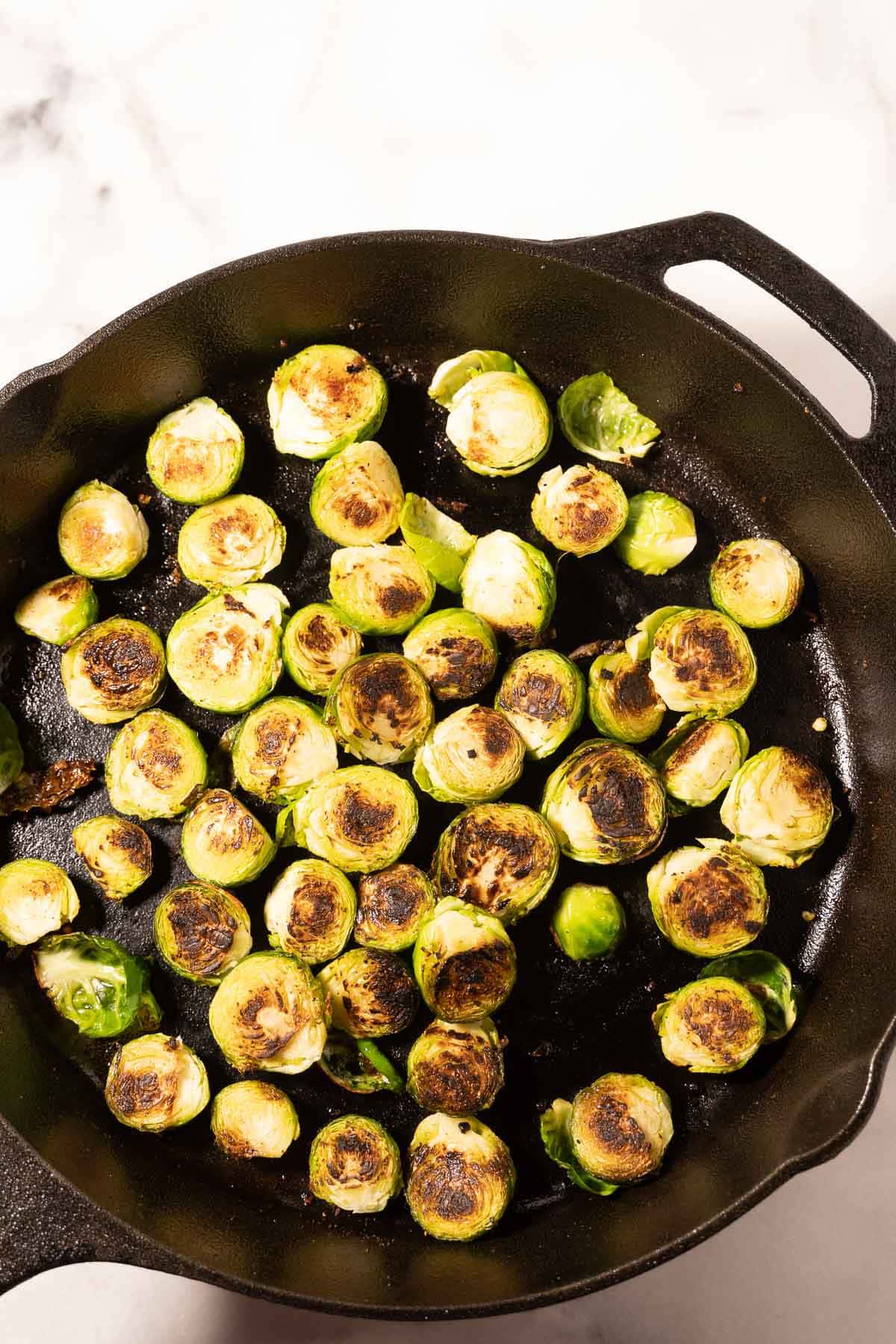 Pan fried brussels sprouts in skillet.