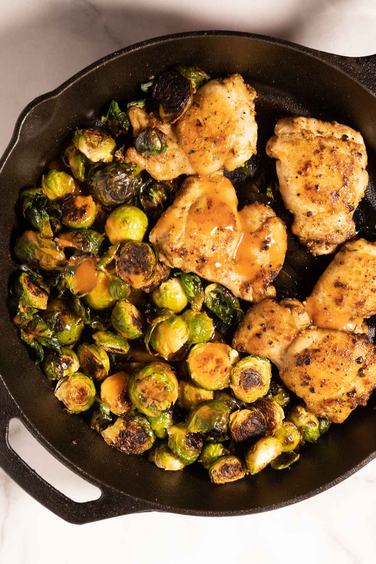 Check thighs, brussels spouts with hot honey sauce in skillet.