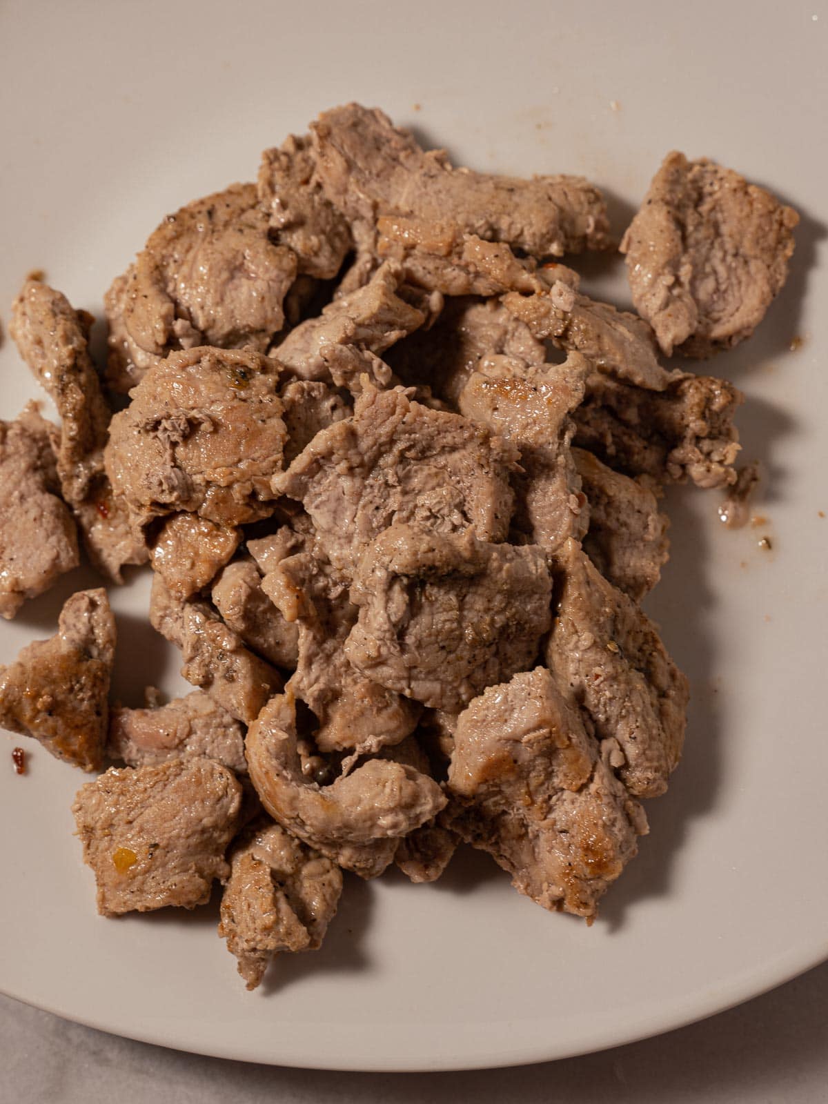 Stir fried pork slices on plate.