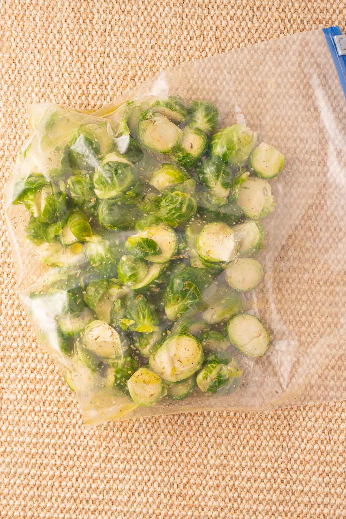 Brussel sprout halves marinating in plastic bag.